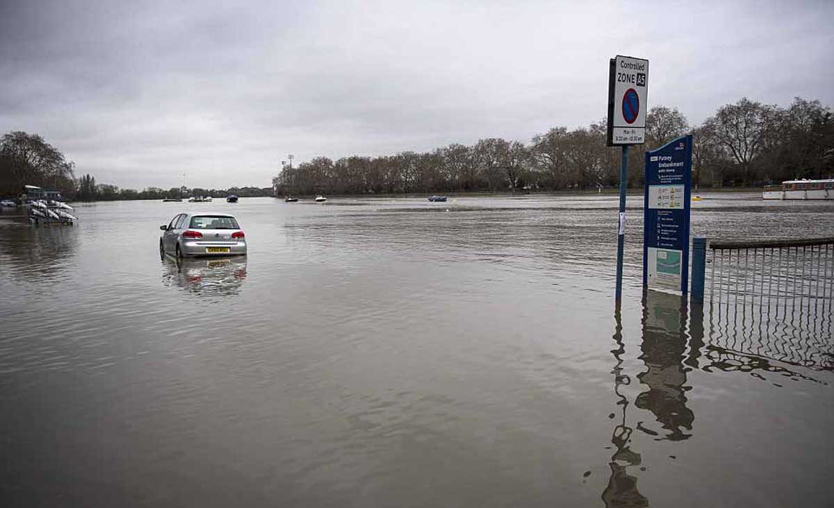 Une voiture est partiellement submergée après que l’eau du sol ait recouvert de nombreuses routes autour du remblai de Putney à l’ouest de Londres après que la Tamise ait rompu ses berges.