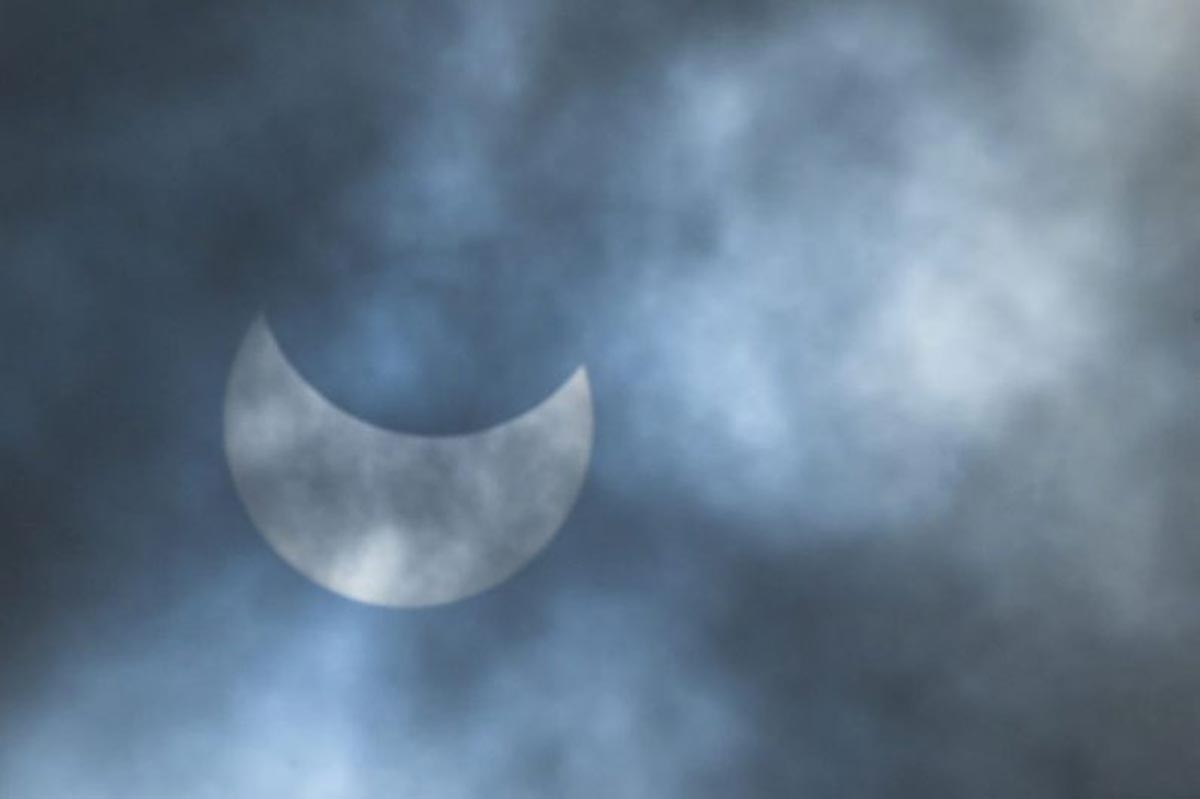 La lune se déplace devant le soleil lors d'une éclipse solaire annulaire vue à travers les nuages à Dhaka.