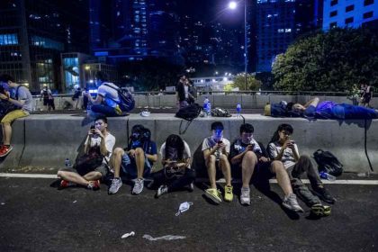 Des manifestants pro-démocratie consultent leur téléphone, à Hong Kong, le 29 septembre 2014.