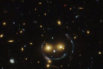 1. L'amas de galaxies SDSS J1038+4849 semble très souriant. Tout y est, ses deux yeux orange, son nez, le contour et la bouche. Ce phénomène est appelé « lentille gravitationnelle ». (Photo : NASA/ESA/Hubble)