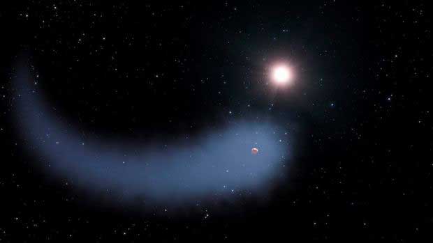 L'exoplanète gravitant autour de sa naine rouge avec son immense nuage de gaz.