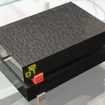 Freebox Révolution posée sur une table en verre, avec un affichage numérique et un design noir gravé.