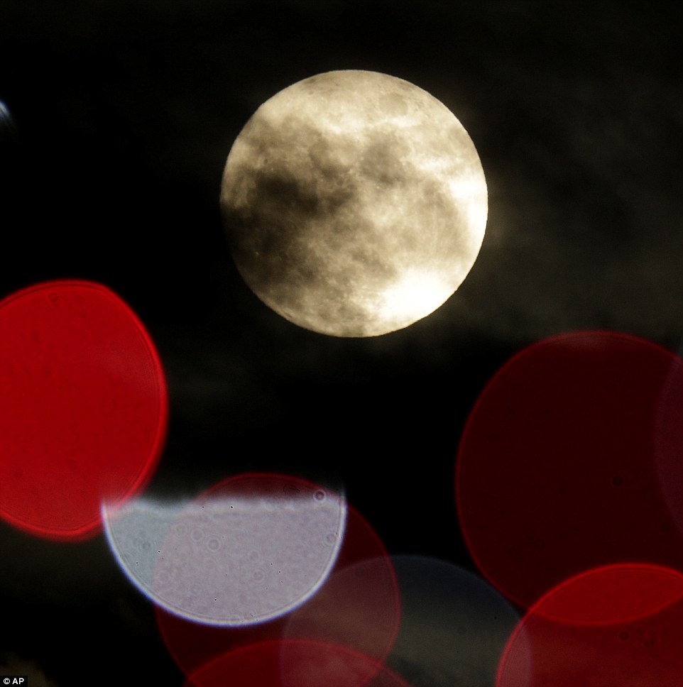 La Lune, presque pleine, entre les lumières des éclairages de Noël à Lenexa, au Kansas, la veille de Noël