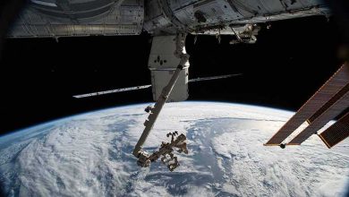 Le vaisseau de ravitaillement SpaceX Dragon et le bras robotique Canadarm2 avec le manipulateur adroit à usage spécial, Dextre, sont illustrés comme la station spatiale orbitant au-dessus du golfe d’Alaska.