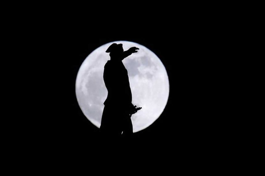Une Super Lune se lève derrière une statue de George Washington le lundi 1er janvier 2018 à Trenton, New Jersey.