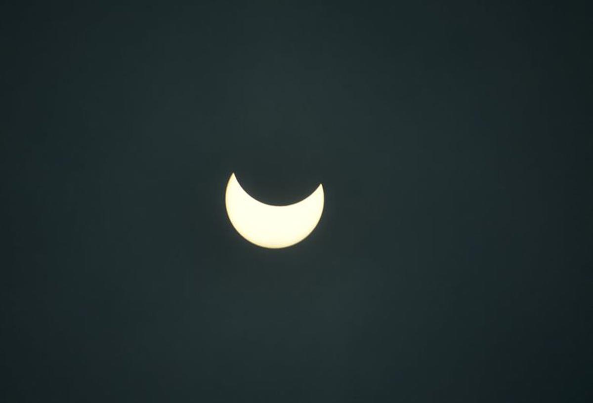 La lune couvre partiellement le soleil pendant l'éclipse solaire annulaire, vue de Siliguri.