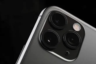 Gros plan sur le module photo arrière à trois objectifs d'un iPhone gris sombre.