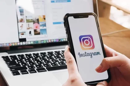 Suppression d’un compte Instagram depuis un smartphone, avec l’application affichée à l’écran devant un ordinateur portable