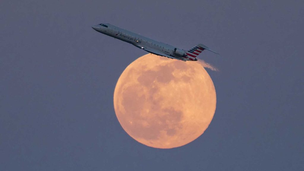 Un jet traverse le ciel lors de la superlune du 26 avril 2021, appelée lune rose. f/4.0, ISO 1250, 1/1000 sec., 500.0 mm.
