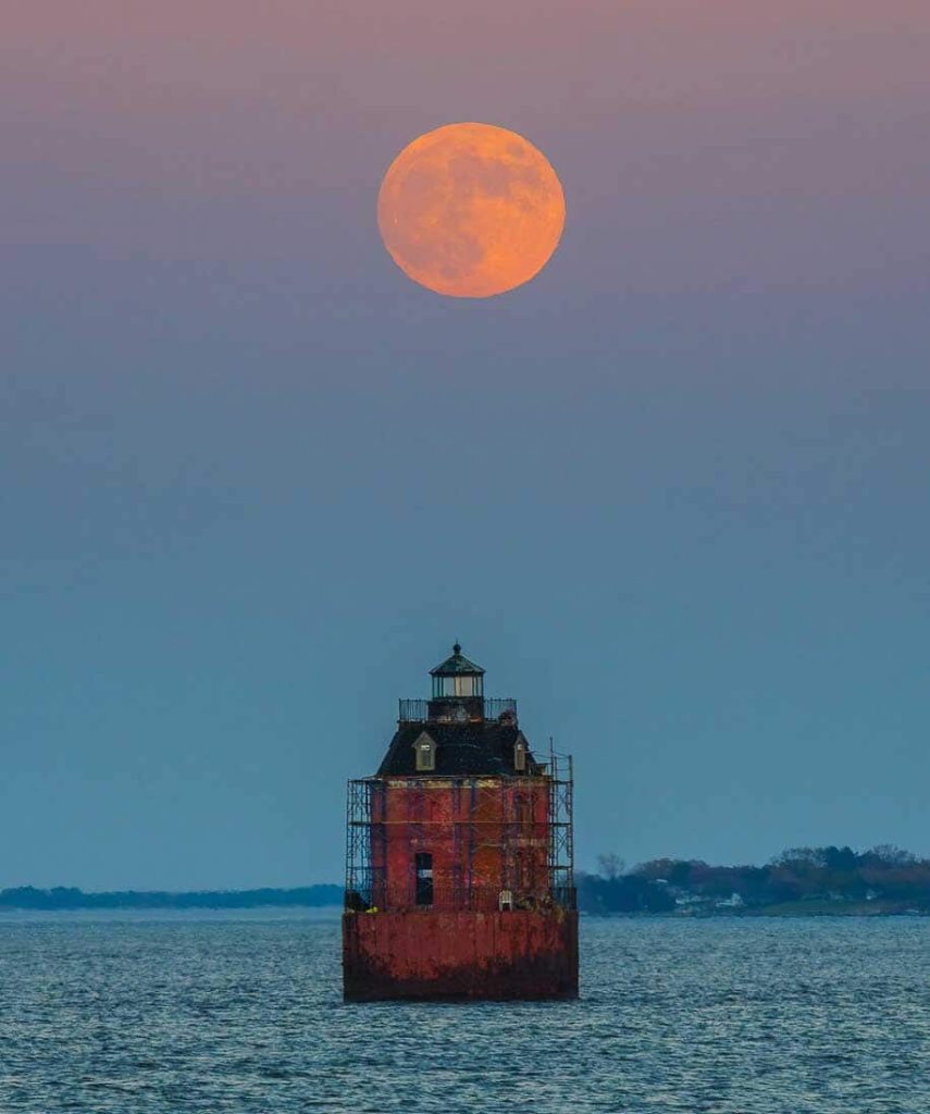 La pleine lune se lève sur le phare de Sandy Point Shoal.