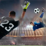 Un joueur de football en bleu effectue un retourné acrobatique face à un gardien tentant d'arrêter le ballon dans un grand stade illuminé.
