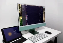 Écran d'un iMac affichant l'application CyberGhost VPN, avec un iPad Pro connecté au VPN, sur un bureau minimaliste.