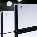 Console PlayStation 5 vue de près, avec des reflets lumineux en arrière-plan.