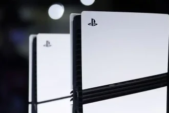 Console PlayStation 5 vue de près, avec des reflets lumineux en arrière-plan.