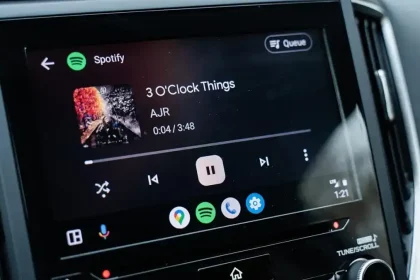 Écran d’une voiture affichant l’interface Android Auto avec Spotify en lecture, mettant en avant une navigation simplifiée et un lecteur multimédia optimisé.