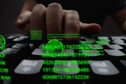 Clavier d'ordinateur utilisé par un cybercriminel avec des données numériques affichées en vert, symbolisant une cyberattaque.