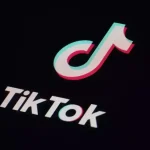 Logo TikTok blanc et couleur sur fond noir, application de partage de vidéos.