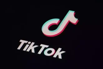 Logo TikTok blanc et couleur sur fond noir, application de partage de vidéos.