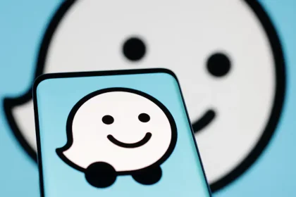Logo de l’application Waze affiché sur un smartphone, avec un fond flou reprenant l’icône de l’application.