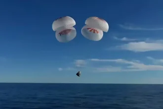 La capsule Crew Dragon de SpaceX, suspendue à quatre parachutes, amorce son amerrissage dans l'océan Atlantique après une mission prolongée sur l’ISS.