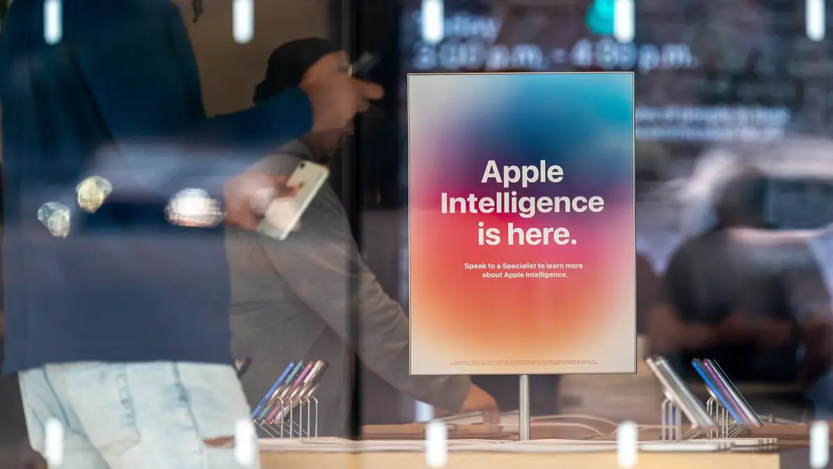 Affiche Apple Intelligence en vitrine d’un Apple Store, avec des clients en arrière-plan