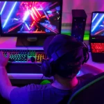 Joueur sur PC équipé d’un casque, en pleine session gaming avec affichage coloré sur deux écrans.