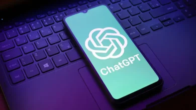 Smartphone affichant le logo ChatGPT posé sur le clavier d’un ordinateur portable, illustrant l’intégration de l’IA dans les usages numériques quotidiens.