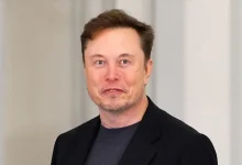 Elon Musk en veste noire, regard direct, lors d’un événement officiel