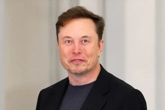 Elon Musk en veste noire, regard direct, lors d’un événement officiel