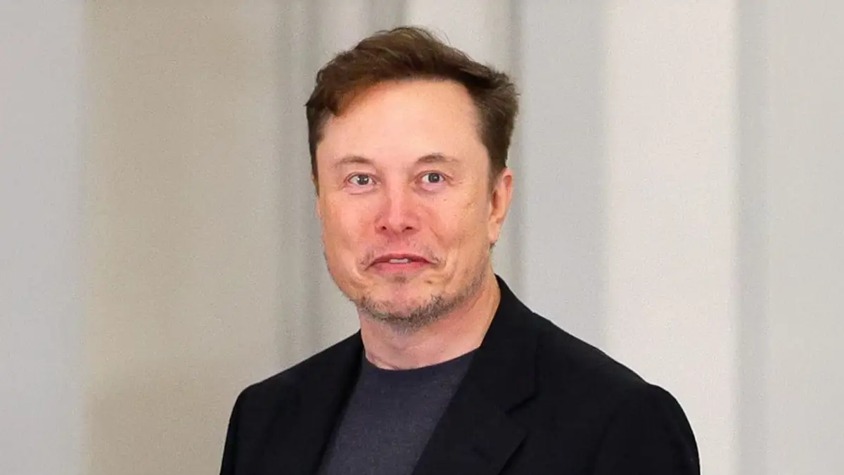 Elon Musk en veste noire, regard direct, lors d’un événement officiel