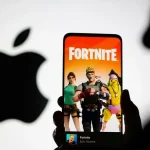 Un smartphone affichant l’écran d’accueil de Fortnite devant le logo Apple en arrière-plan.