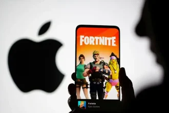 Un smartphone affichant l’écran d’accueil de Fortnite devant le logo Apple en arrière-plan.