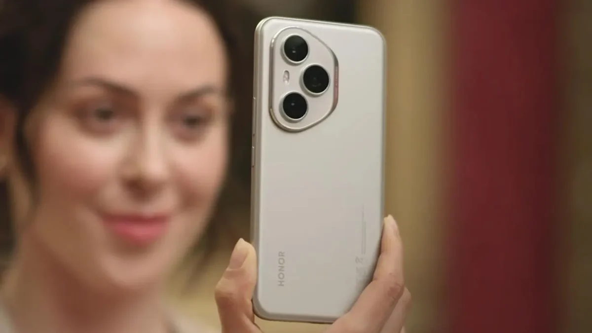 Une femme tenant un smartphone Honor 400 doté d’un triple module photo, face à l’objectif.