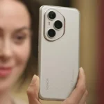 Une femme tenant un smartphone Honor 400 doté d’un triple module photo, face à l’objectif.