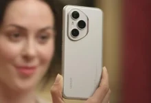 Une femme tenant un smartphone Honor 400 doté d’un triple module photo, face à l’objectif.