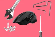 Souris Logitech noire entourée d’outils de réparation sur fond rose