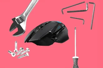 Souris Logitech noire entourée d’outils de réparation sur fond rose