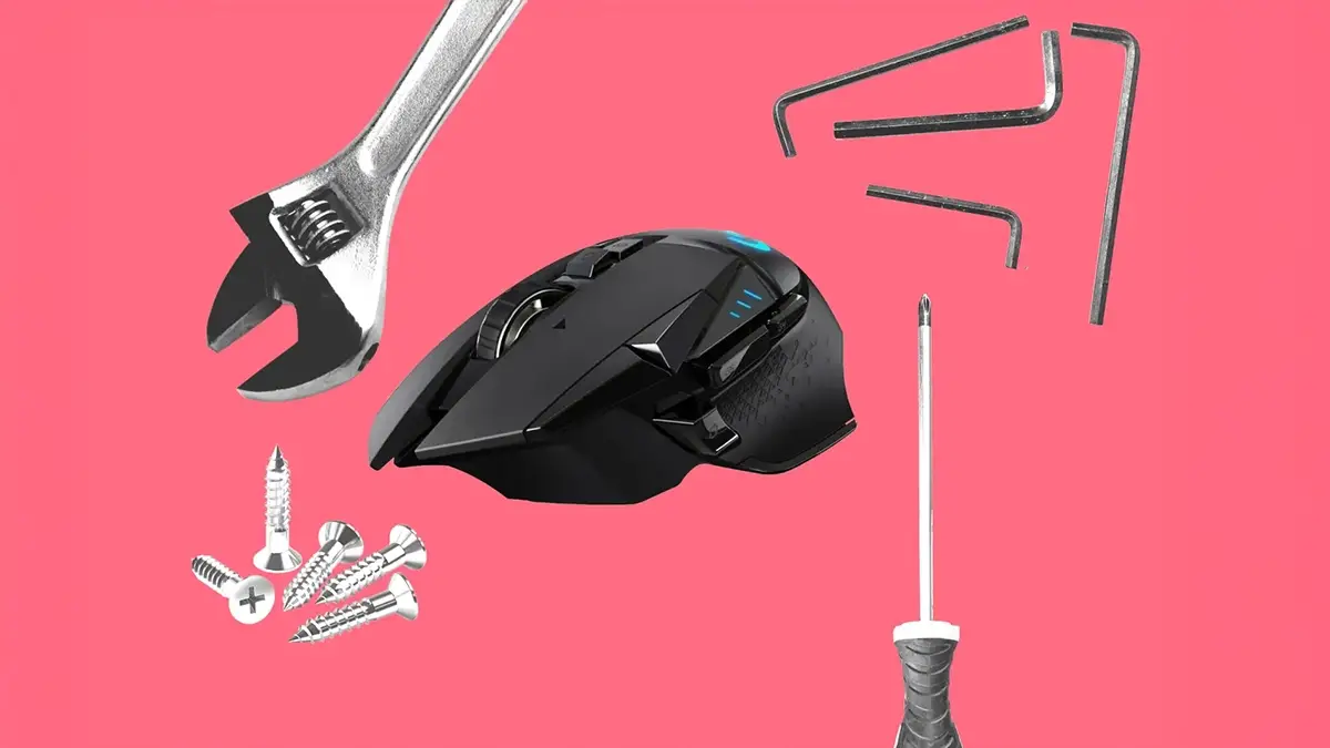 Souris Logitech noire entourée d’outils de réparation sur fond rose