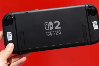 Console Nintendo Switch 2 noire vue de dos avec logo central visible, tenue en main