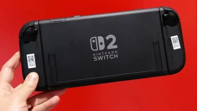 Console Nintendo Switch 2 noire vue de dos avec logo central visible, tenue en main