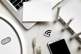 Vue de dessus d’un routeur Wi-Fi entouré d’appareils connectés, smartphone, câble réseau et robot aspirateur