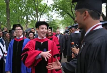 Mark Zuckerberg en toge universitaire échange avec un diplômé lors d'une cérémonie à Harvard