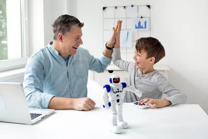 Un père et son fils sourient et se donnent un high five devant un robot interactif, symbole des nouveaux cadeaux fête des pères inspirés par l’intelligence artificielle.