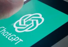 Main posée sur l’écran d’un smartphone affichant le logo vert de ChatGPT