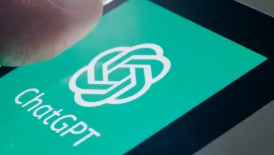 Main posée sur l’écran d’un smartphone affichant le logo vert de ChatGPT