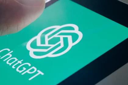 Main posée sur l’écran d’un smartphone affichant le logo vert de ChatGPT