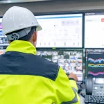 Technicien surveillant en temps réel la consommation énergétique sur plusieurs écrans dans une salle de contrôle