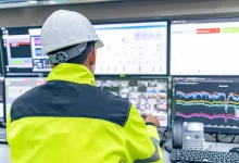 Technicien surveillant en temps réel la consommation énergétique sur plusieurs écrans dans une salle de contrôle