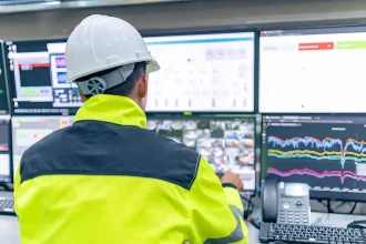 Technicien surveillant en temps réel la consommation énergétique sur plusieurs écrans dans une salle de contrôle