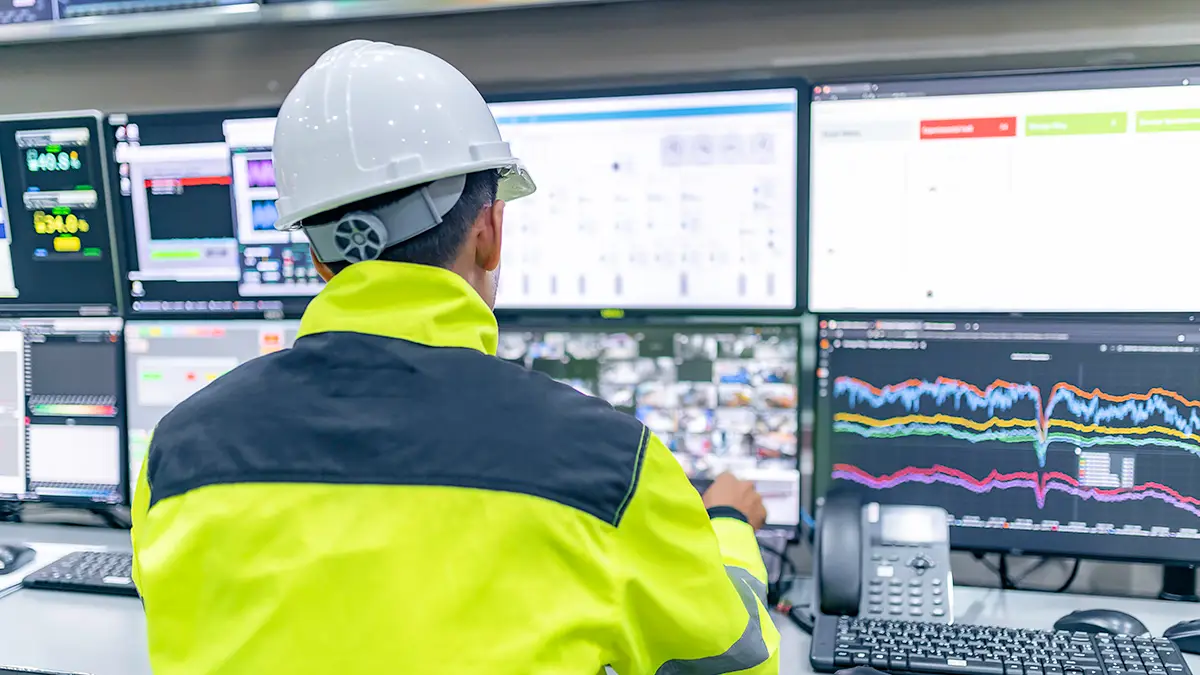 Technicien surveillant en temps réel la consommation énergétique sur plusieurs écrans dans une salle de contrôle